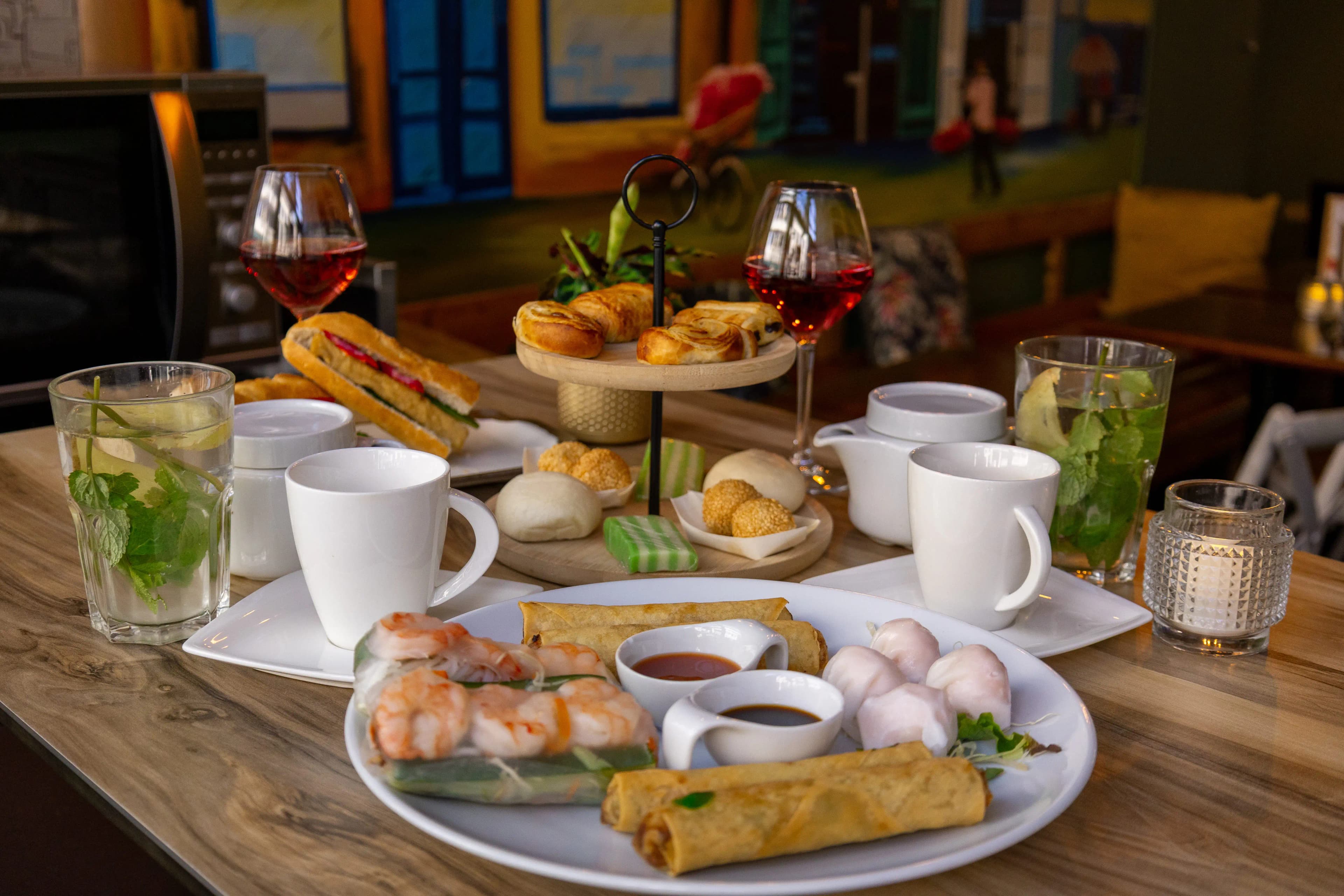 High tea menu with spring rolls, fruit and cakes