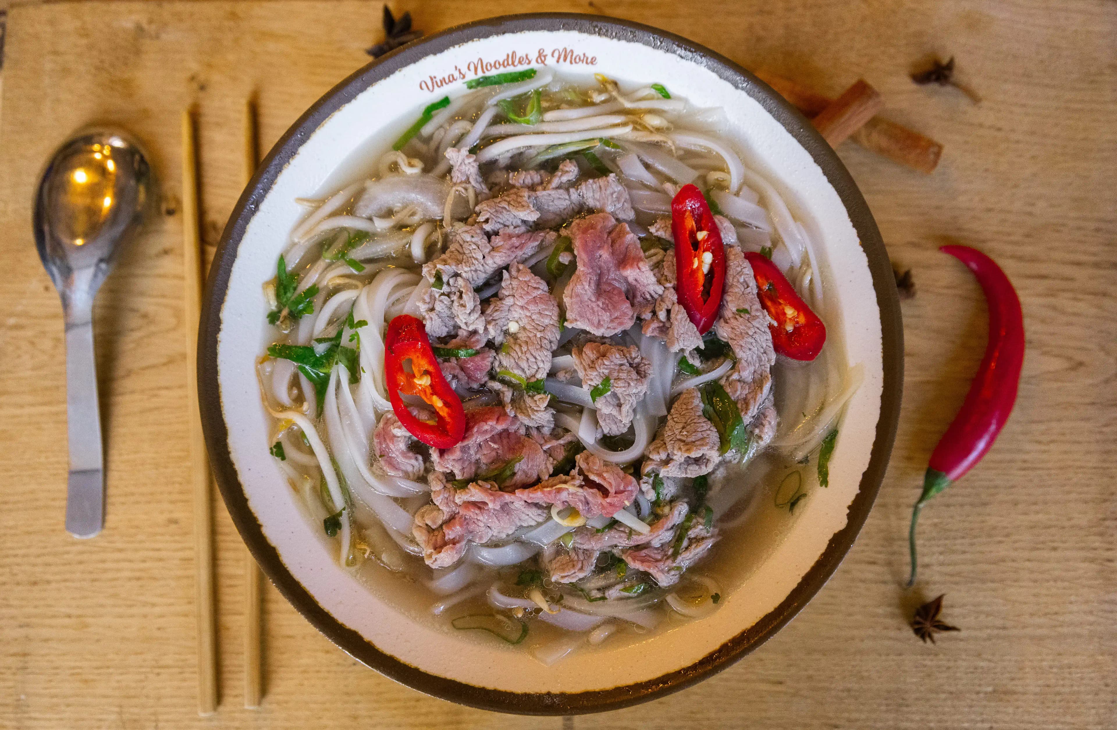 A bowl of Vietnamese pho with fresh herbs